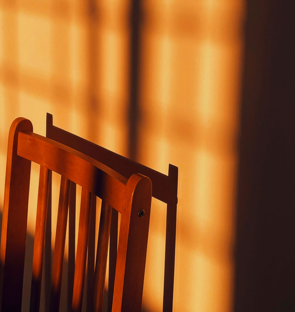 Close up of a bowl of the top of a kitchen chair lit by golden hour light